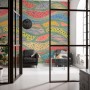 Bunte Komar Vliestapete Wave Symphony im Wohnraum mit Sesseln.