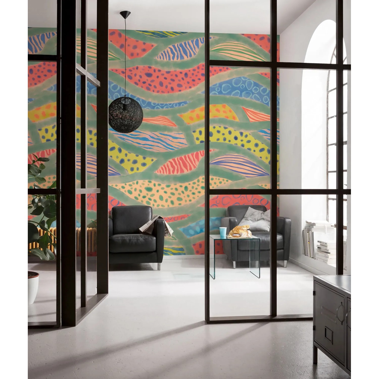 Bunte Komar Vliestapete Wave Symphony im Wohnraum mit Sesseln.