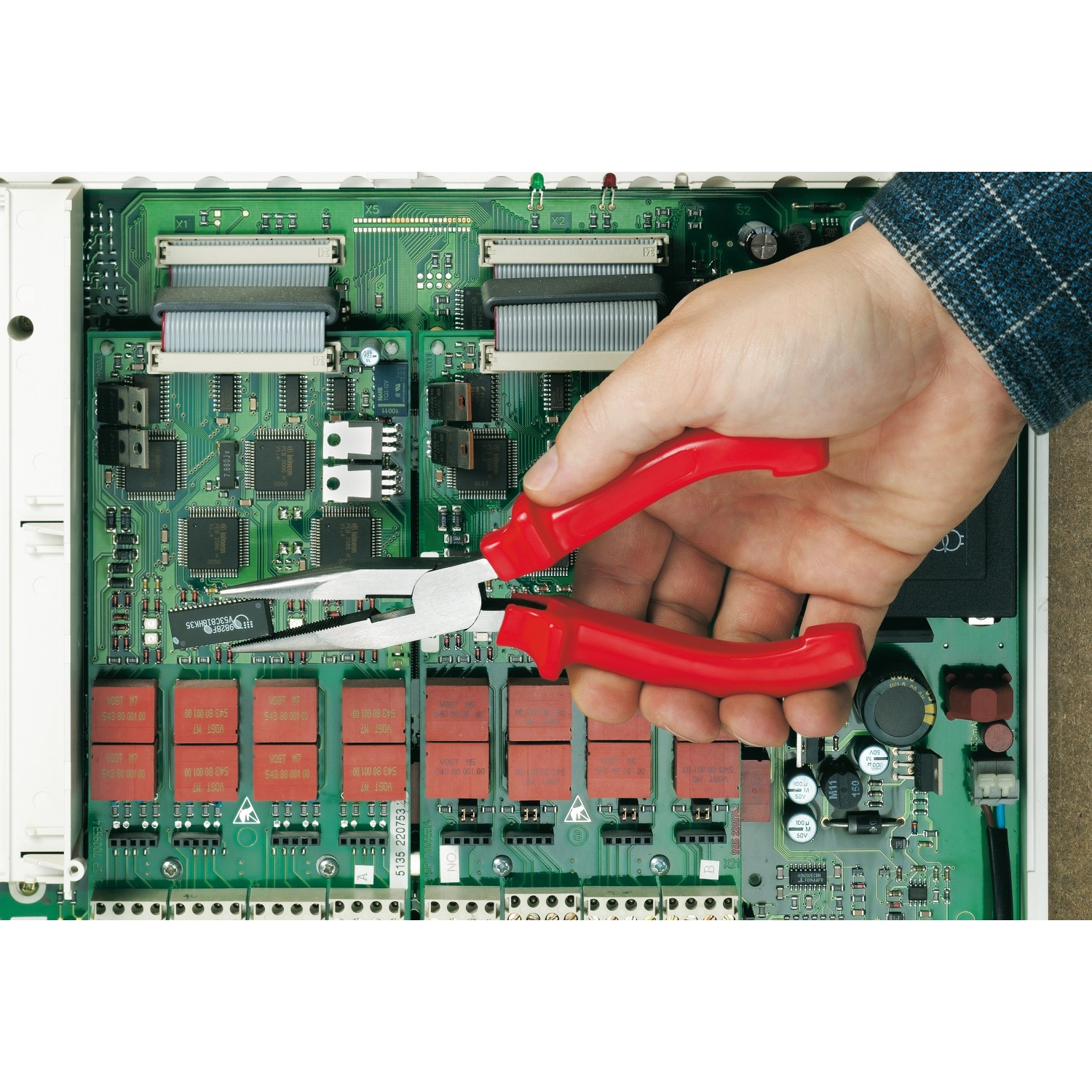 Ellix Zangen Set, 3-teilig, im Einsatz an einer Platine. Zangen mit roten Griffen.