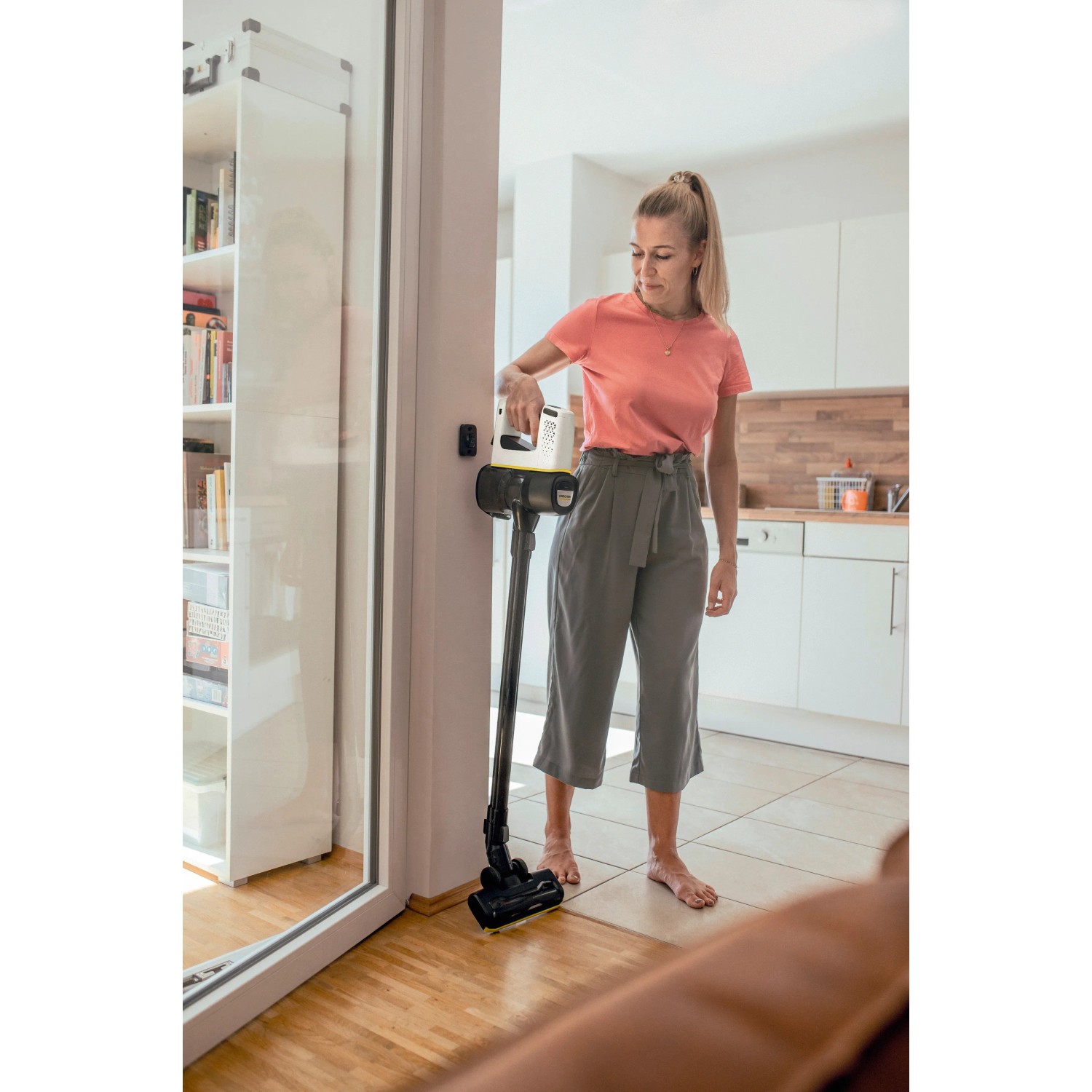 Frau nutzt Kärcher Akku-Staubsauger VC 4 Cordless myHome in Wohnung. Bodenstaubsauger mit Akku.