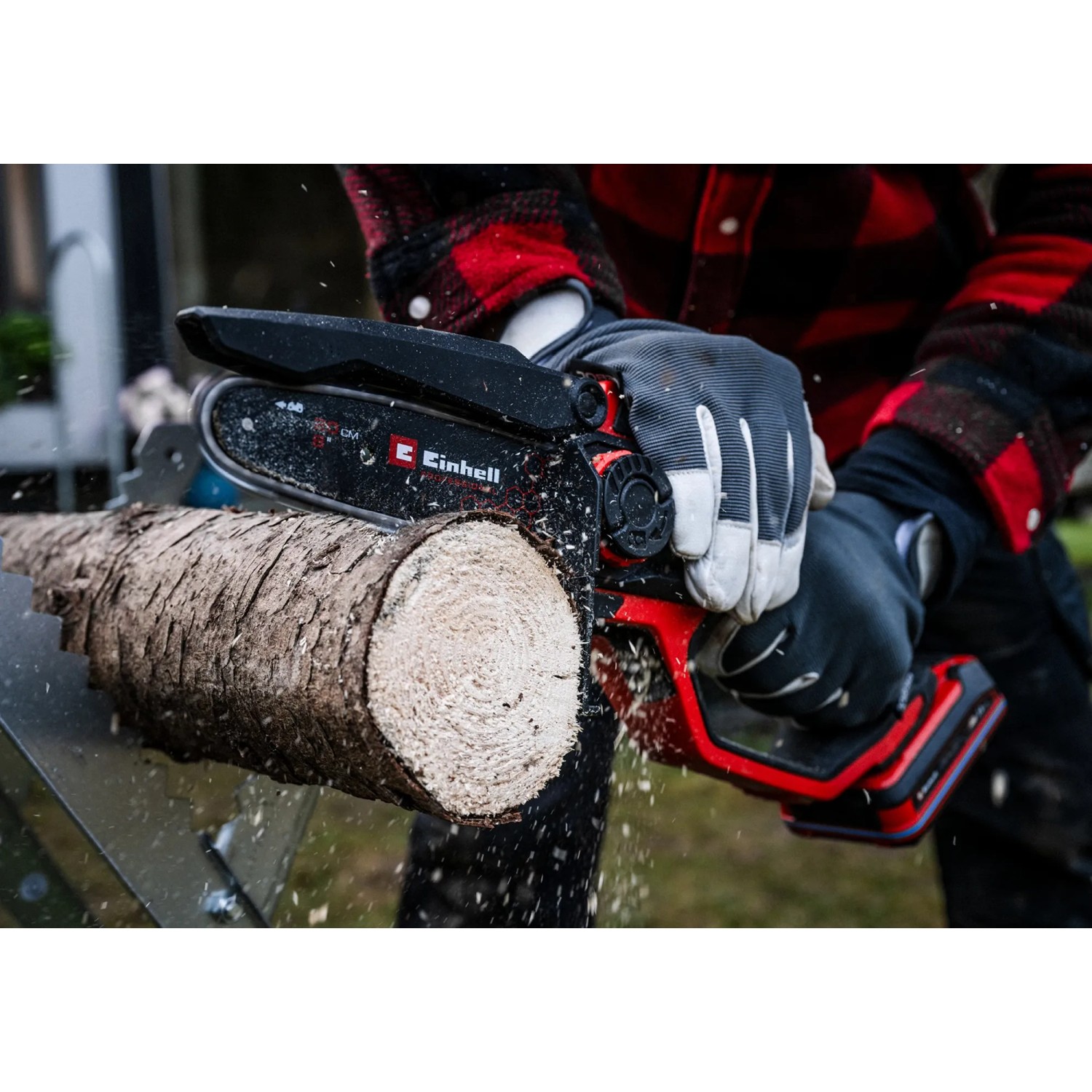 Einhell Akku-Astkettensäge GP-PS 18/20 Li BL-Solo beim Sägen eines Baumstamms.