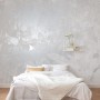 Komar Vlies Fototapete Flora 400x280 cm im Schlafzimmer mit floralem Muster in Weiß und Grau.