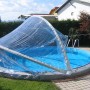 Runde, transparente Chemoform Pool-Abdeckung Cabrio Dom SH Ø 320 cm x 145 cm über einem Pool.