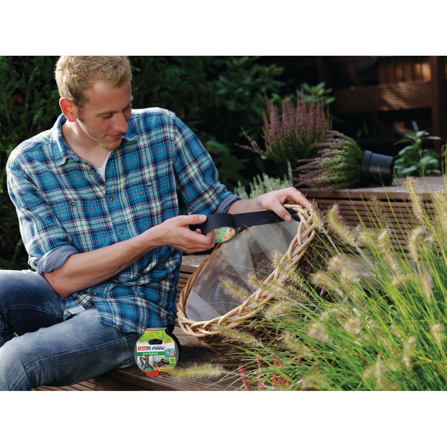 Mann repariert Weidenkorb mit schwarzem Tesa Extra Power Eco Repair Gewebeband.