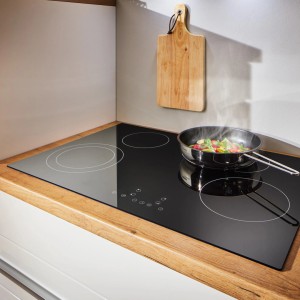 Respekta Backofen-Set mit Glaskeramikkochfeld und Pfanne mit Gemüse auf Kochfeld.