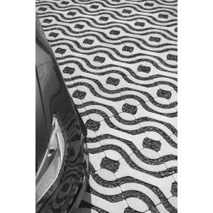 Häusler Pflaster Kreativ Steingrau, befahrbare Terrassenplatten mit wellenförmigem Muster und Auto.