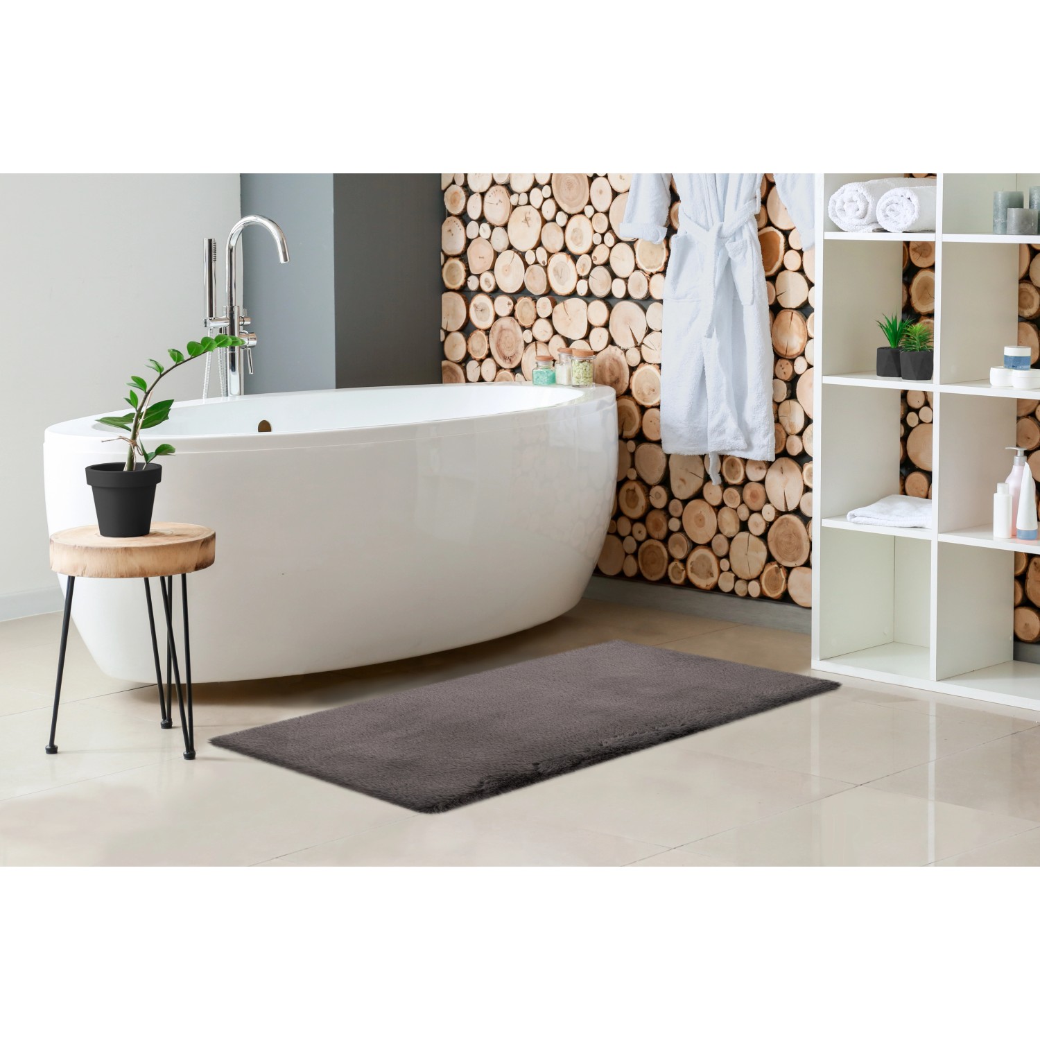 Grauer Lalee Badteppich Heaven, 40x60 cm, im Badezimmer mit Badewanne und Dekoration.