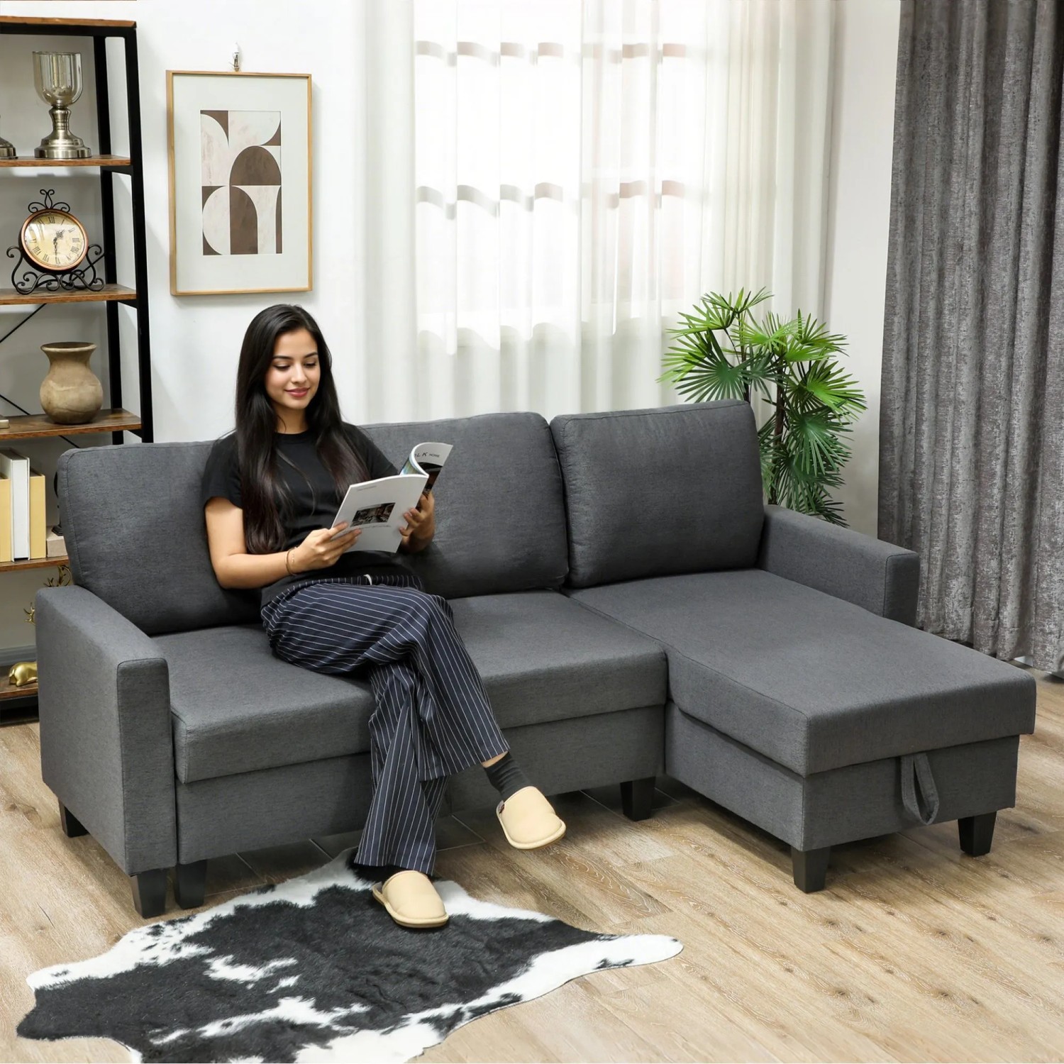 Dunkelgraues Ecksofa mit Schlaffunktion und Stauraum-Chaiselongue aus Stoff in Leinenoptik im Wohnzimmer.