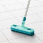 Leifheit Gummibesen Click-System, mintgrün, mit Teleskopstiel auf weißen Fliesen.
