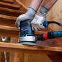 Bosch Exzenterschleifer mit Netzschleifscheibe M480 Körnung 120 im Einsatz auf einer Holztreppe.