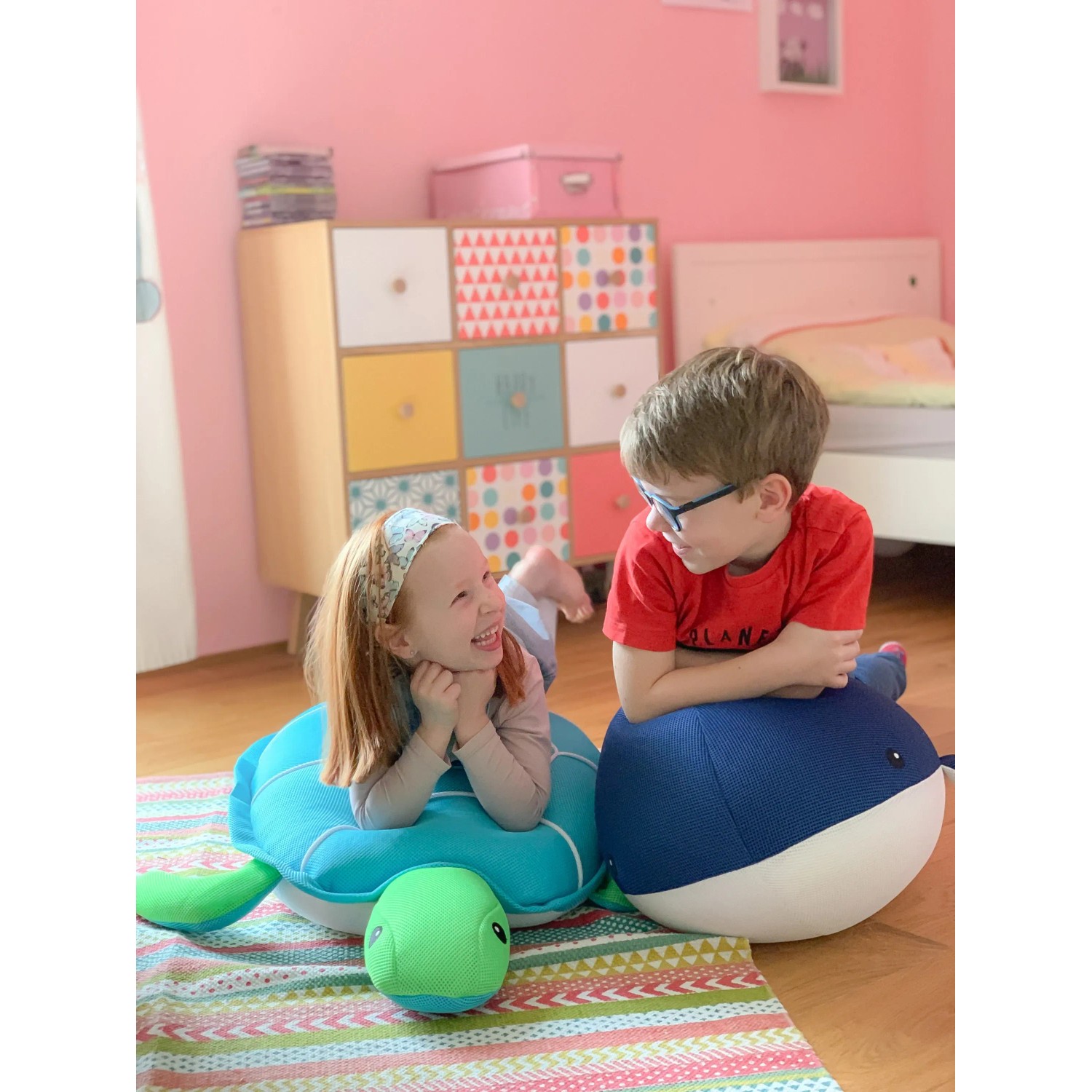 Kinder spielen mit Westmann Pool Buddy Schildkröte (blau) und Wal als Sitzsack im Kinderzimmer.