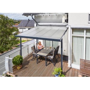 Moderne Gutta Terrassenüberdachung in Anthrazit mit Polycarbonatplatten und sitzender Person am Tisch.