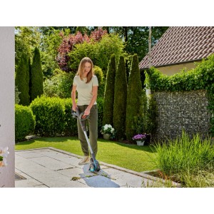 Frau nutzt Gardena Akku-Fugenbürste EasyWeed mit Nylon-Fugenbürste zur Unkrautentfernung.