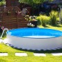 Steinbach Stahlwandpool-Set Nuovo Ø 550 cm im Garten mit Leiter und blauem Wasser.