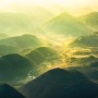 Komar Fototapete Vlies The Shire: Hügelige Landschaft im Morgenlicht, ideal für Kinderzimmer.