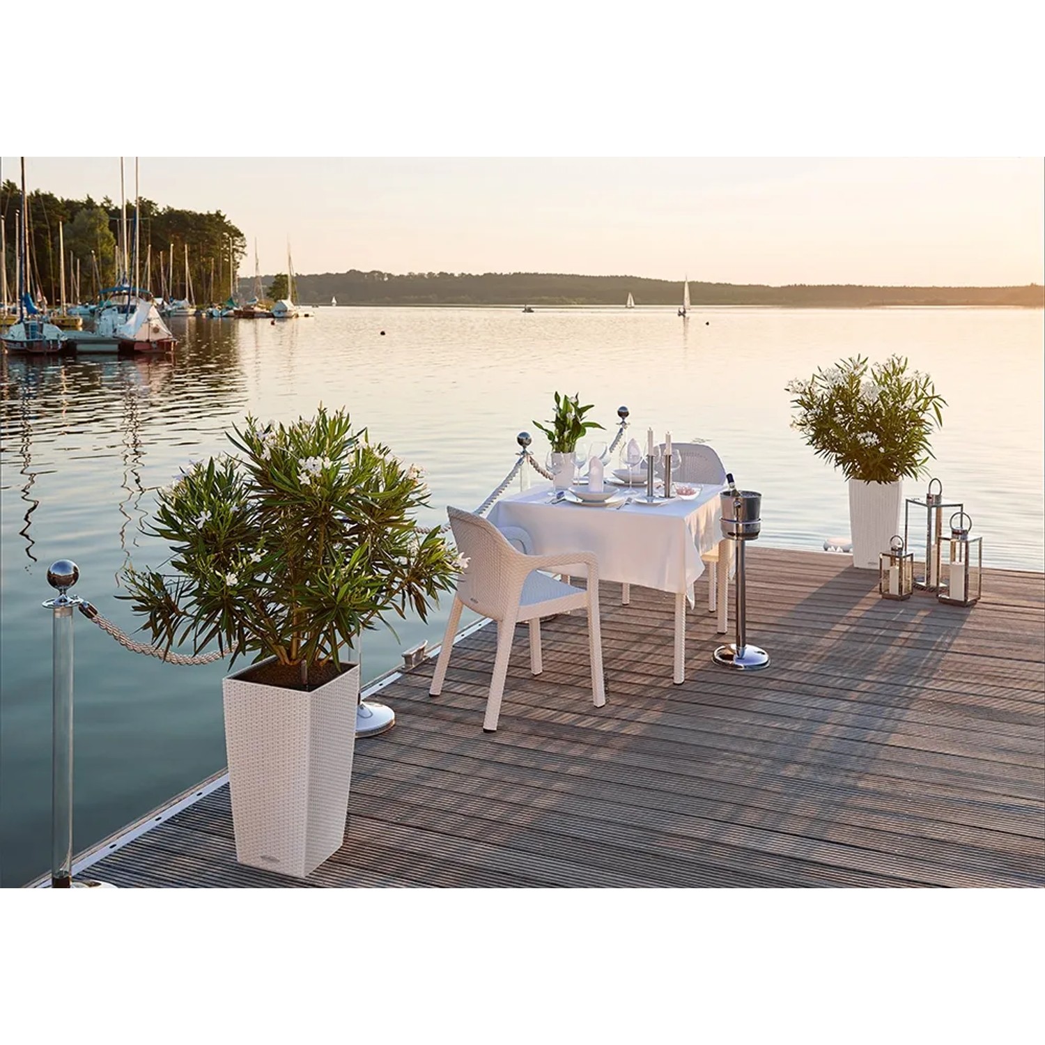 Weißer Lechuza Essstuhl aus Kunststoff, Teil eines Outdoor-Essbereichs am See.