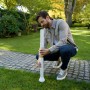 Mann installiert ECOVACS Navigations-Beacon für GOAT Mähroboter im Garten.