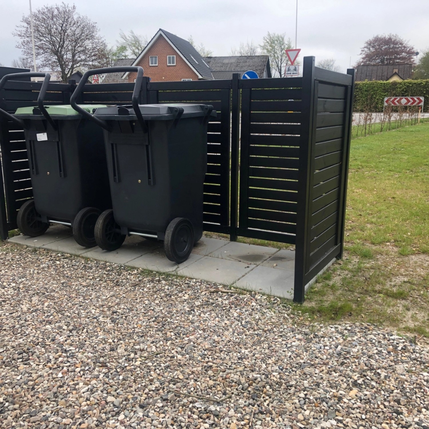 Schwarze Mülltonnenverkleidung Lund (245x85x124cm) aus Holz im Außenbereich.
