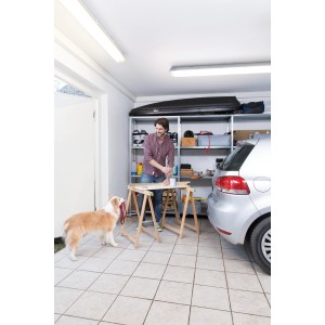 Mann arbeitet in Garage mit Ledvance LED-Feuchtraumleuchte. Werkstattbeleuchtung mit kaltweißem Licht.