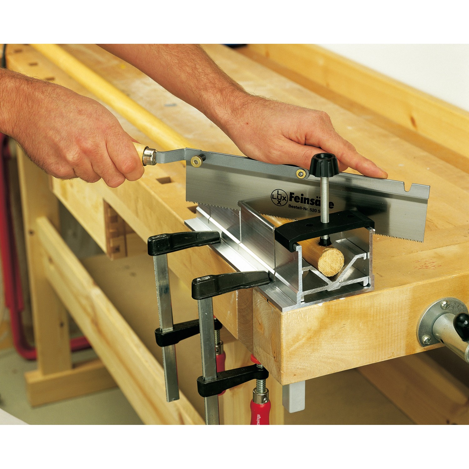 LUX Feinsäge Classic beim Sägen von Holz in einer Schneidlade auf einer Werkbank.