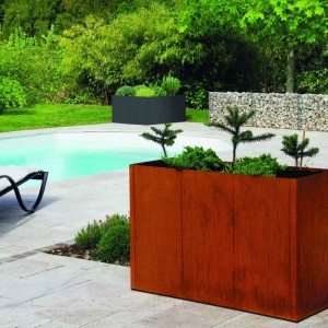 Rostfarbenes bellissa Corten-Hochbeet PANNELLO im Garten neben Pool. Modularer Metall-Bausatz mit Pflanzen.