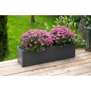 Anthrazitfarbener Westmann Pflanzkübel Talus M mit pinkfarbenen Blumen auf einer Holzterrasse.
