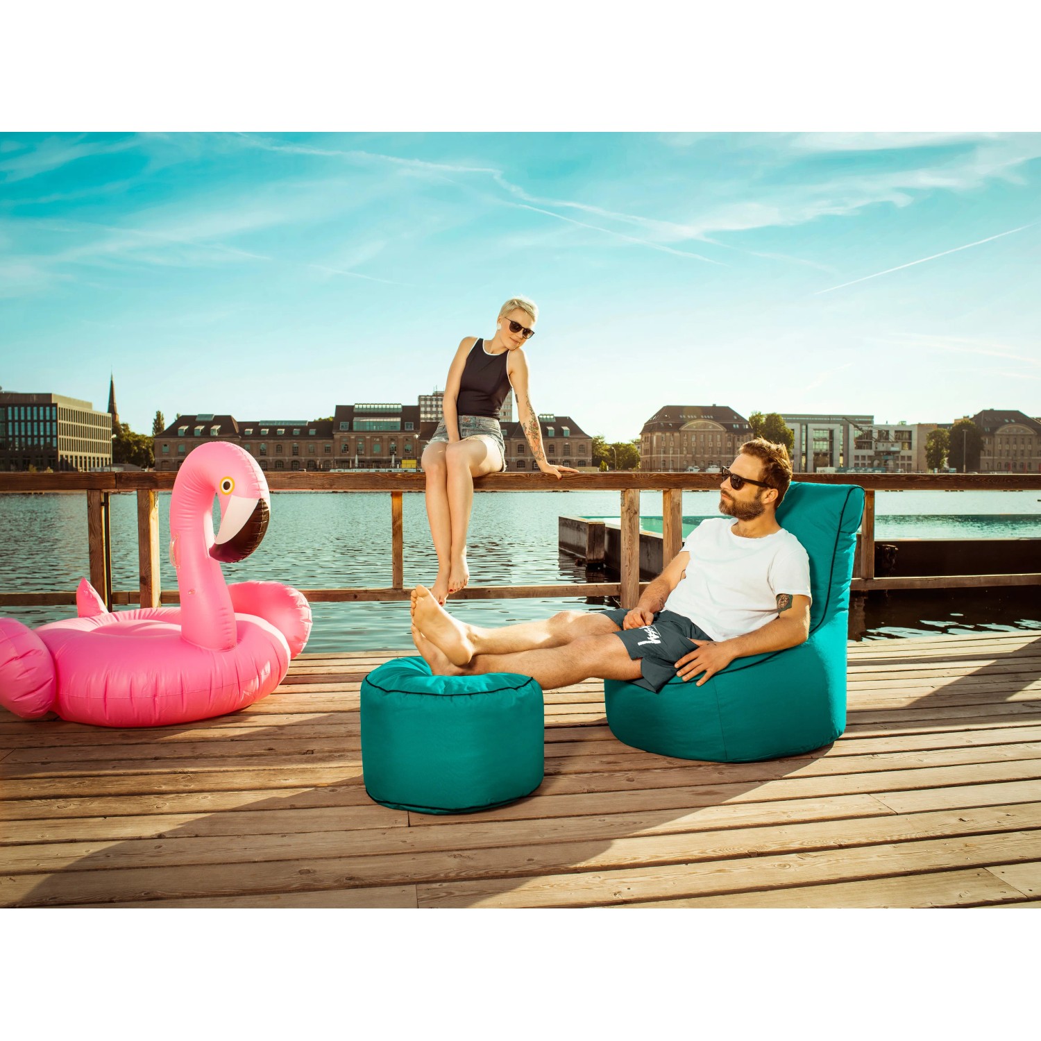 Sitting Point Sessel Swing Anthrazit mit Hocker auf Holzsteg am Wasser.
