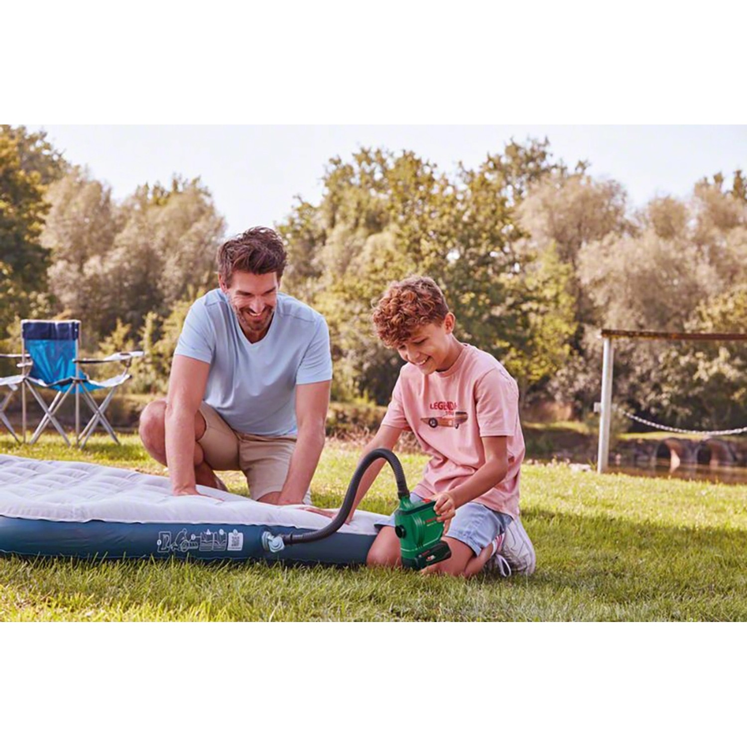 Bosch EasyInflate 18V-500 Akku-Luftpumpe beim Aufpumpen einer Luftmatratze im Freien.