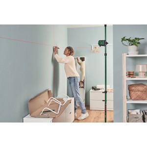 Frau benutzt Bosch UniversalLevel 2 Kreuzlinienlaser zur Ausrichtung an Wand.