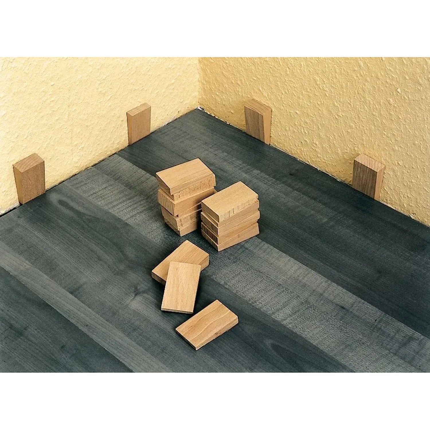 LUX Montagekeile aus Holz, eingesetzt am Boden und an der Wand.