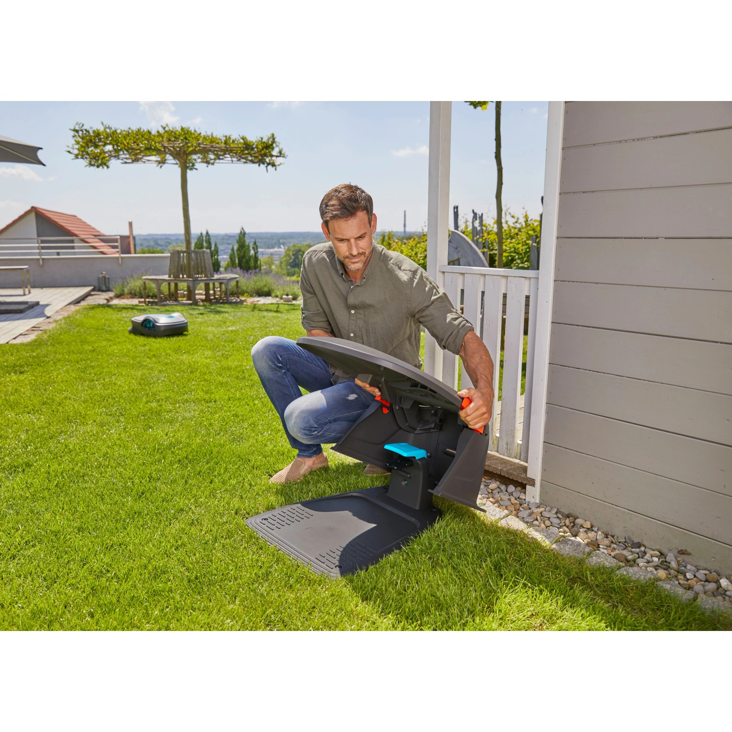 Gardena Garage für Sileno city/life Mähroboter: Mann öffnet Dach für Zugang. Schutz vor Wetter.