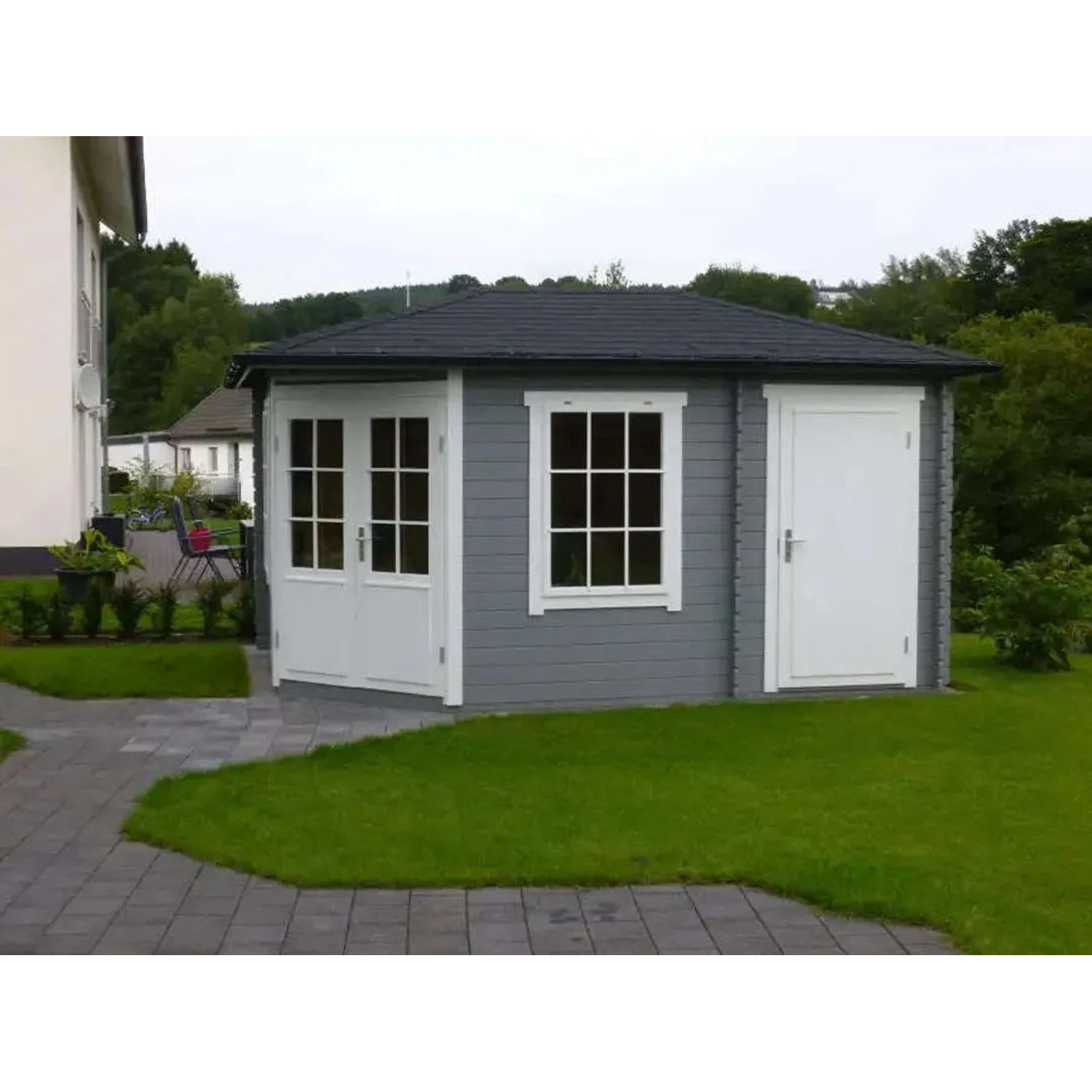 Graues Alpholz Gartenhaus Rhein mit Walmdach und Anbaudach im Garten.