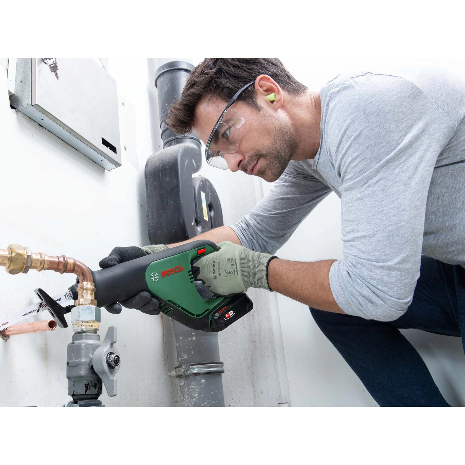 Mann sägt mit Bosch Akku-Säbelsäge AdvancedRecip 18 ein Rohr. Inkl. Akku und Ladegerät.