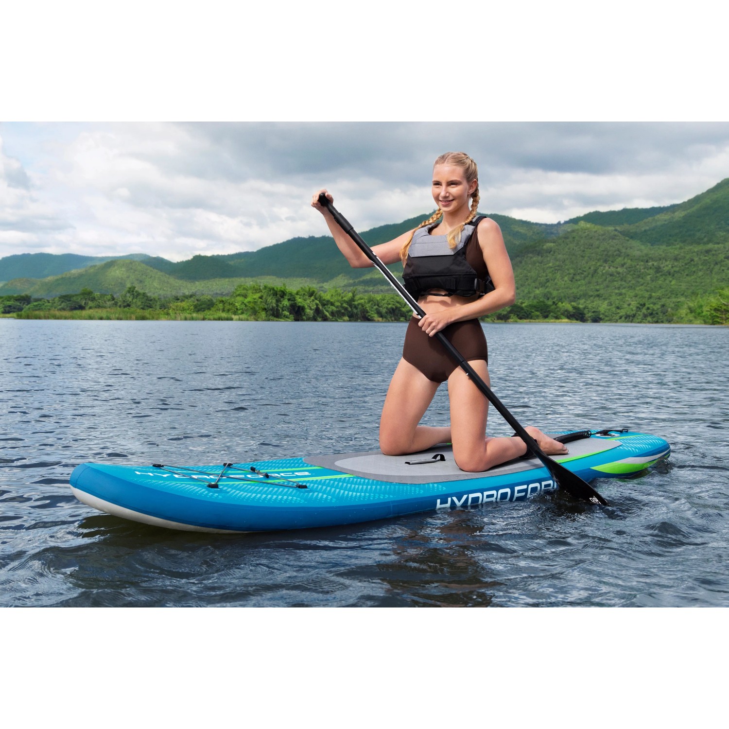 Frau auf blauem Bestway SUP Board Aqua Journey mit Paddel auf dem Wasser.
