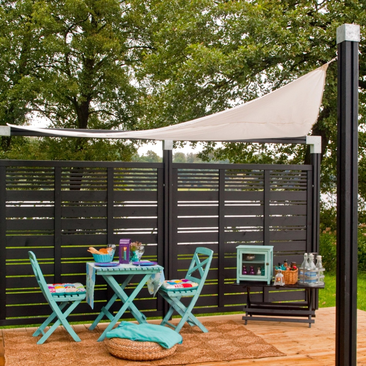 Schwarzer Sichtschutzzaun Silence aus Nadelholz, 176x170cm, mit Gartenmöbeln und Sonnensegel im Garten.
