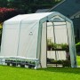 Weißes ShelterLogic Foliengewächshaus 240x180 cm im Garten, bepflanzt mit Blumen und Gemüse.