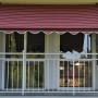 Angerer Klemmmarkise Exklusiv, bordeaux-creme gestreift, 150x150 cm, montiert auf einem Balkon.