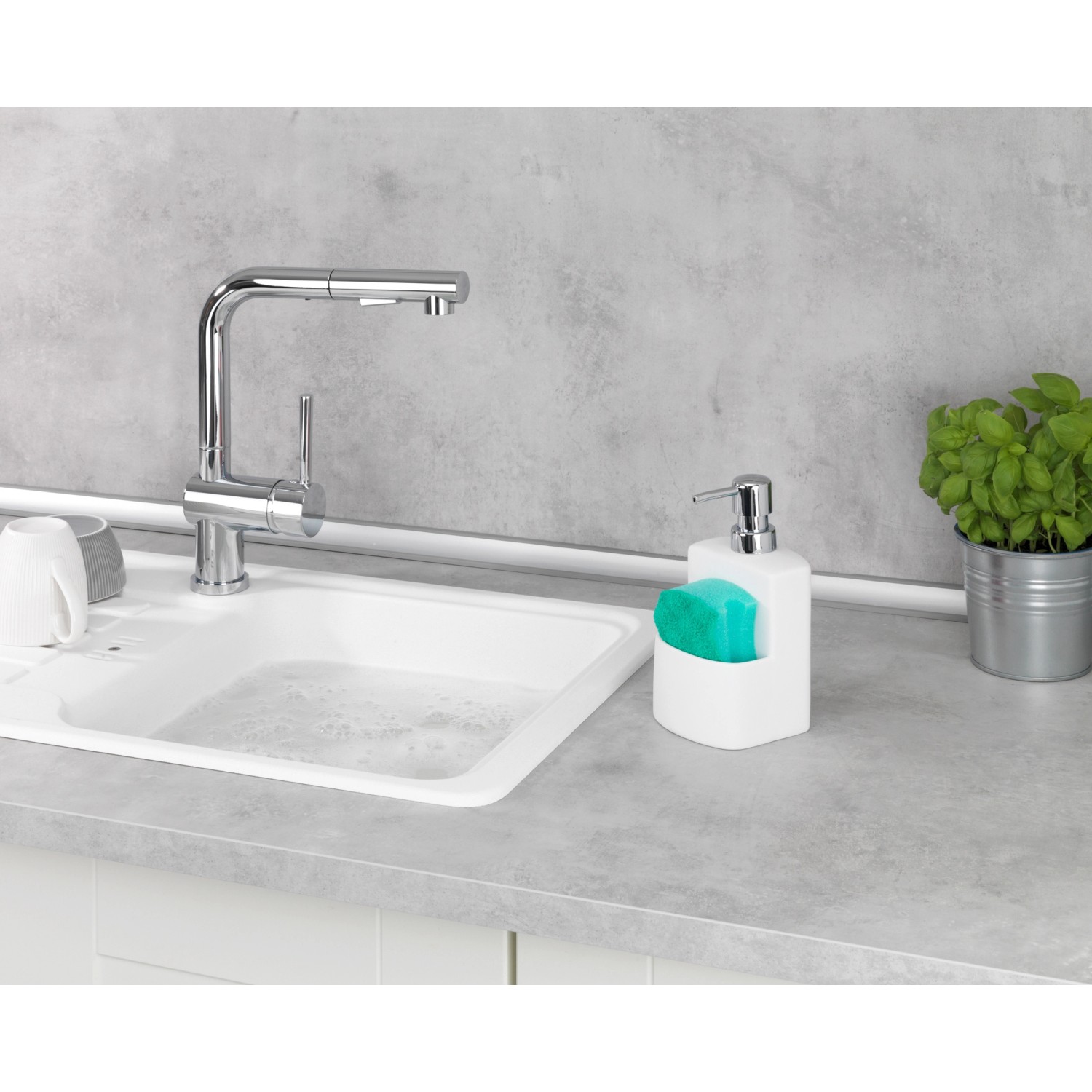 Wenko Spülmittelspender True Colours Festival Weiß mit Schwamm neben Spüle.