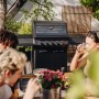 Enders Gasgrill Monroe Pro 3 SIKR Turbo Shadow in Schwarz mit Personen im Garten.