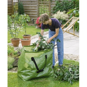 Grüner Gartenabfallsack (245 l) mit Frau beim Befüllen im Garten.