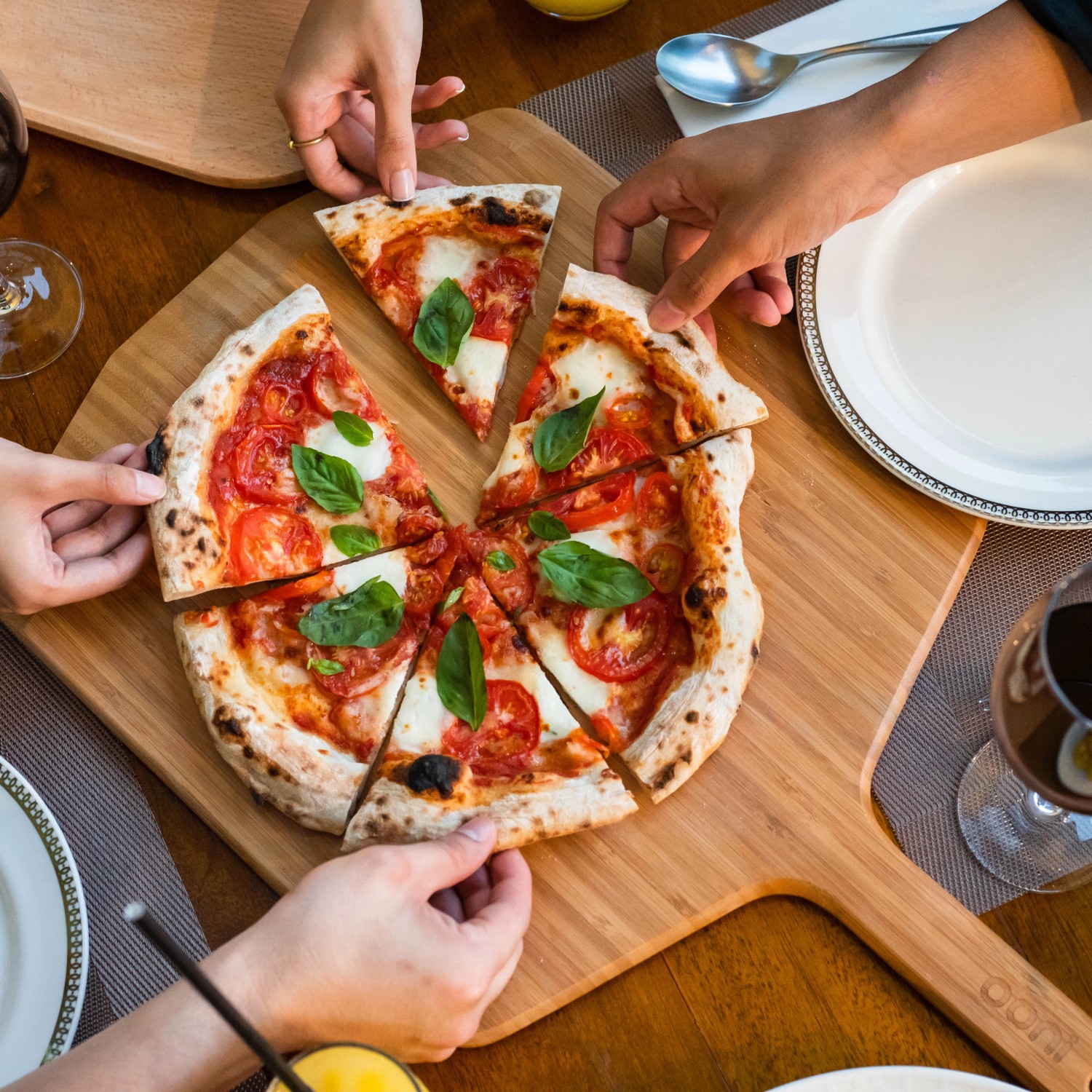 Ooni Pizzaschieber aus Bambus mit Pizza, ideal zum Servieren und Zubereiten von Pizza.
