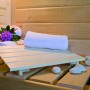Innenansicht der Woodfeeling Sauna Faurin mit Handtuch, Blumen und Steinen auf der Saunabank.