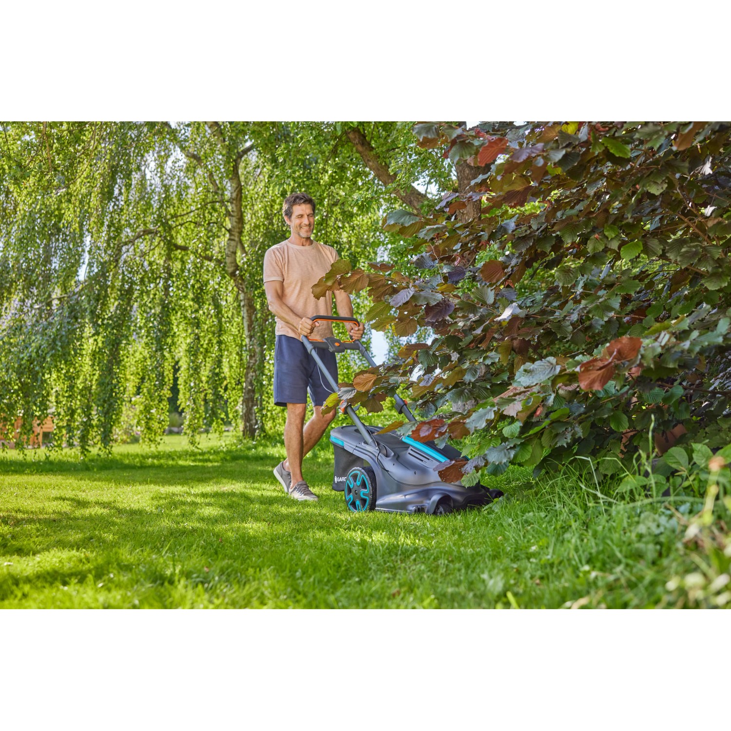 Gardena Akku-Rasenmäher PowerMax Duo beim Rasen mähen im Garten.