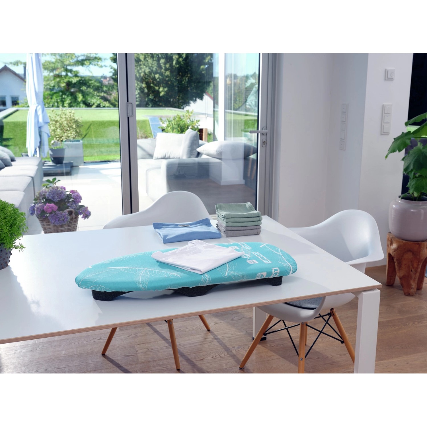 Leifheit AirBoard Compact Tischbügelbrett auf einem Tisch mit Wäsche.