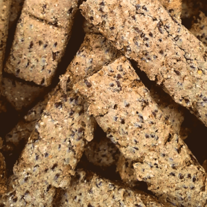 Supravit Leinsamenleckerli für Pferde. Rechteckige, braune Snacks mit grober Textur und sichtbaren Leinsamen.