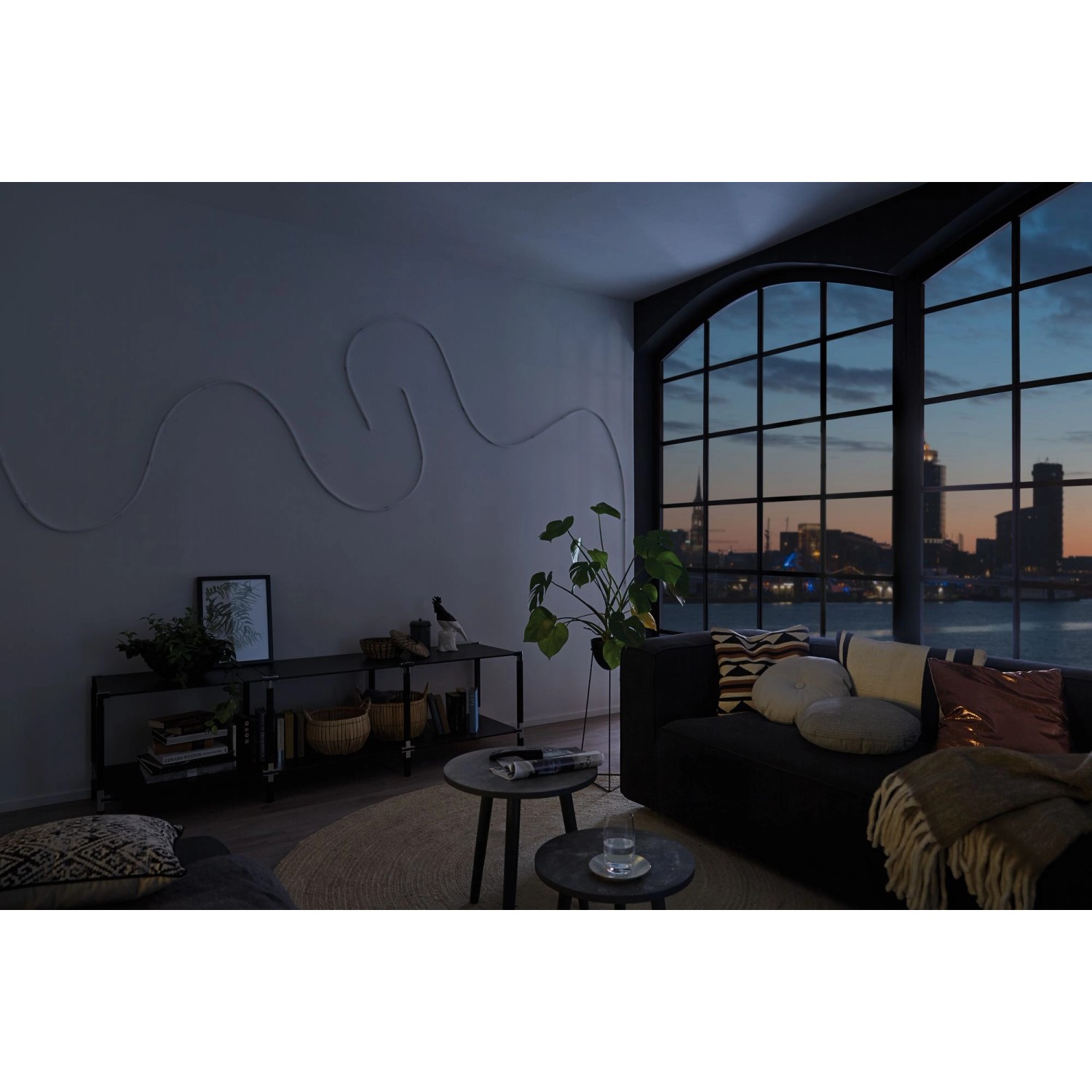 Wohnzimmer mit indirekter Beleuchtung durch Paulmann MaxLED Flow RGB LED-Streifen an der Wand.