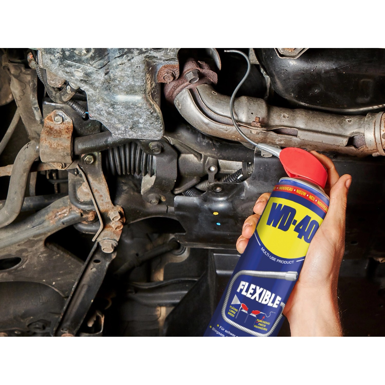 WD-40 Flexible Multifunktionsprodukt in Anwendung zur Autoreparatur. Schmiert schwer erreichbare Stellen.