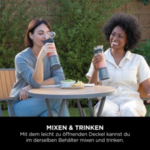 Zwei Frauen genießen Smoothies aus dem blauen Ninja Mixer Blast BC151EUNV im Freien.