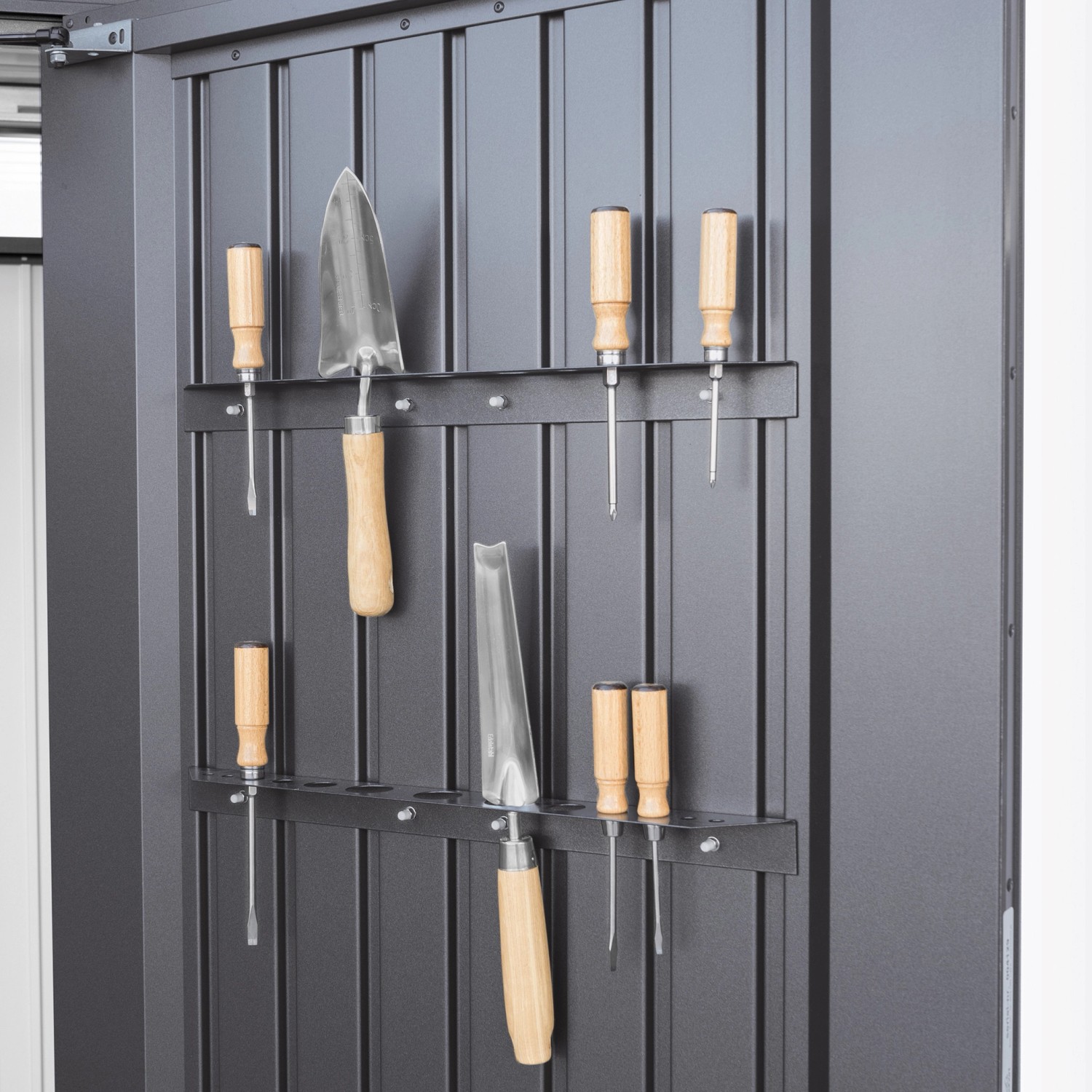 Werkzeuge an der Wandhalterung im Biohort Gerätehaus HighLine, dunkelgrau-metallic.