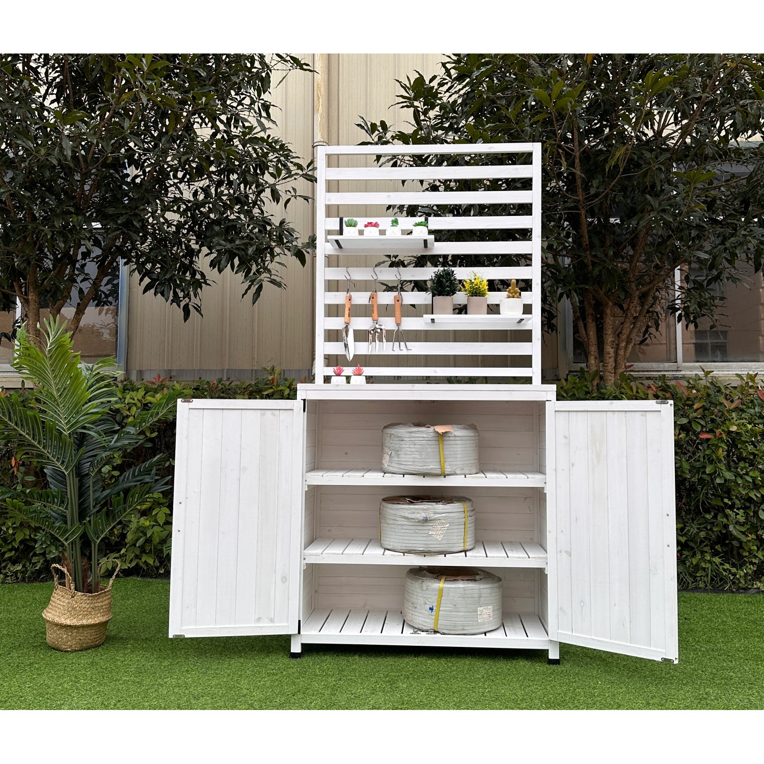 Weißes Leco Gartenregal Thea mit Ablageflächen und Schrankraum für Gartengeräte.